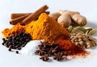 Aromatic spices and herbs collection with turmeric, paprika, cinnamon, ginger, cardamom, salt, and peppercorns on white background for cooking.