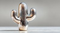 Shiny metallic chrome cactus sculpture on white surface against neutral background for modern home decor and contemporary interior design concepts.