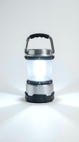 Portable LED camping lantern with metallic silver and black design, featuring collapsible structure and carrying handle for outdoor adventures and emergency lighting.