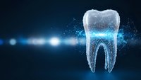 Digital tooth with glowing particles and light effects on dark blue background for dental technology and healthcare innovation concepts.