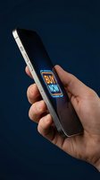 Male hand holding smartphone with glowing neon buy now button on screen, dark blue background, mobile shopping and e-commerce concept.