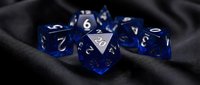 Blue translucent polyhedral dice set with white numbers on dark fabric background for tabletop gaming and role-playing adventures.