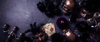 Dark mystical still life with tarot cards, black roses, candles and crystal ball on purple textured surface for fortune telling and divination themes.
