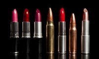 Row of lipsticks and bullets on black background showing similarity between cosmetics and ammunition, highlighting contrast between beauty and danger.