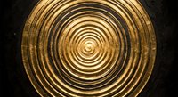 Golden metallic spiral pattern with concentric circles creating hypnotic depth and dimension on dark textured background for modern design projects.