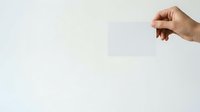 Male hand holding blank white card or paper against neutral background for mockup and branding purposes.