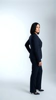 Professional woman with long black hair and South Asian ethnicity wearing dark navy business suit standing in profile against white background, suitable for corporate, business, and professional design projects.