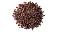 Pile of dark chocolate chips or cacao nibs on white background, raw ingredient for baking, cooking, and dessert preparation.