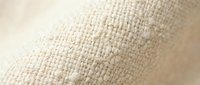 Close-up of natural beige burlap fabric texture showing detailed weave pattern and fiber structure for rustic design projects and craft applications.