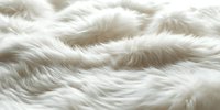 Luxurious white fur texture with soft waves and natural folds creating cozy winter atmosphere, suitable for fashion and interior design backgrounds.
