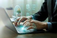 Businessman hands typing on laptop with digital technology icons and data analytics symbols floating above keyboard in modern office environment.