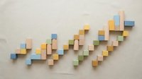 Colorful wooden blocks arranged in ascending pattern on neutral background creating growth chart visualization for business presentations.