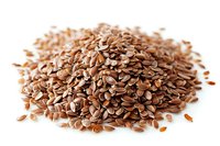 Heap of brown flax seeds isolated on white background, rich in omega-3 fatty acids and dietary fiber for healthy nutrition and cooking.