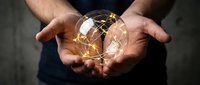 Male hands holding glowing digital globe with golden network connections representing global business technology and worldwide communication solutions.