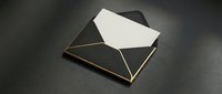 Elegant black envelope with white card emerging, featuring gold trim details on dark surface for luxury correspondence and invitation designs.