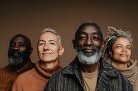 Diverse group of senior adults with gray beards and stylish clothing posing against brown background, representing aging with confidence and style.