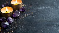 Glowing candles and raw amethyst crystals on dark textured background with golden glitter scatter. Spiritual wellness and meditation atmosphere for spa decor.
