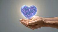 Glowing digital heart with geometric wireframe pattern floating above open cupped hands against soft gradient background for healthcare technology concepts.