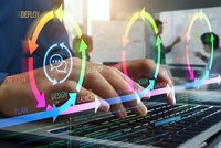 Software development lifecycle concept with colorful arrows showing agile methodology stages over programmer hands typing on laptop keyboard.