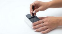 Female hands with manicured nails holding and touching a smartphone screen against white background for technology and communication concepts.