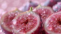 Fresh ripe figs cut in half showing juicy pink flesh and seeds with natural bokeh background, macro food photography for healthy eating concept.