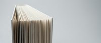 Open book with fanned pages creating accordion effect on neutral background for education, literature, and reading concepts in publishing design.