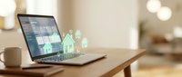 Digital real estate platform on laptop screen showing property listings with holographic house icons emerging from keyboard for online home buying.