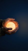 Person holding glowing orb against dark night sky, symbolizing hope, energy, and inspiration for motivational and spiritual concepts.