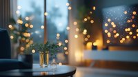 Cozy winter evening atmosphere with golden bokeh lights through window, evergreen branches in vase on table, warm candlelight creating festive holiday mood.