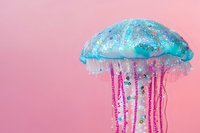 Jellyfish with glittering turquoise dome and pink tentacles adorned with beads on soft pink background. Isolated decorative element suitable for creative projects and design work.