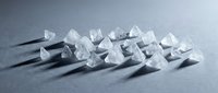 Clear crystal chunks arranged in rows on gray surface with tweezers, suitable for mineral, gemstone, laboratory, scientific research, and educational content.