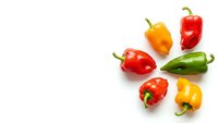 Fresh colorful bell peppers in red yellow orange and green arranged on white background isolated for cooking and healthy eating recipes.