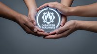 Emergency preparedness and disaster response concept with diverse hands protecting a glowing sphere displaying flame and disaster readiness icon against neutral background.