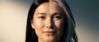 Young Asian woman portrait showing aging process transformation from youth to elderly with wrinkles and gray hair against gradient background.