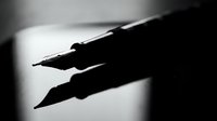 Silhouette of two calligraphy pens or brushes with pointed tips against a soft light background, suitable for art, writing, and design projects.