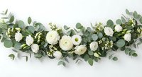 Elegant white ranunculus and eucalyptus garland arrangement on white background, perfect for wedding decor, bridal styling, and romantic event design projects.
