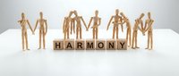 Wooden figures holding hands in circle around harmony wooden blocks on white surface, representing teamwork, unity, cooperation and community support.