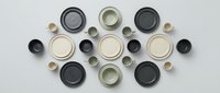 Ceramic dinnerware set with plates and bowls in neutral colors arranged symmetrically on white background, perfect for kitchen and dining decor.