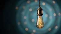 Vintage Edison bulb hanging with warm glowing filament against blurred bokeh lights background for interior design and lighting concepts.