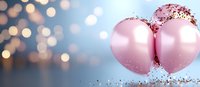 Pink party balloons decorated with silver glitter confetti against blurred bokeh background, festive celebration atmosphere with soft pastel colors.