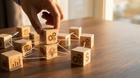 Business strategy concept with hand arranging wooden blocks featuring icons representing growth, innovation and success on office desk.