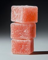 Stacked pink fruit gummies coated with sugar crystals against a dark background, perfect for food and confectionery advertising projects.
