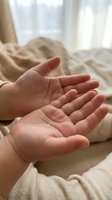 Two small open palms of a young child stretched forward on a soft beige background, symbolizing innocence, care, and new beginnings.