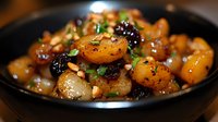 Roasted baby potatoes with dried cranberries and fresh herbs in cast iron skillet. Savory side dish with caramelized vegetables and seasonal garnish.