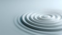 Concentric ripples on calm water surface creating a serene, minimalist pattern in soft blue-gray tones.