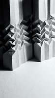 Abstract geometric paper sculpture with angular folded forms creating dramatic shadows and depth in monochrome composition for modern design projects.