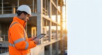 Construction worker in safety vest using tablet at building site during golden hour for project management and digital workflow documentation.
