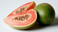 Fresh ripe guava fruit sliced showing pink flesh and seeds isolated on white background ready for healthy eating and tropical cuisine designs.