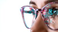 Young woman wearing glasses with digital glitch effect overlay, close up view of eyewear reflecting modern technology and cybersecurity concept.