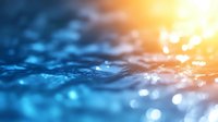 Mesmerizing water surface with blue ripples and golden sunlight creating dreamy bokeh effect, abstract nature background for tranquil designs.